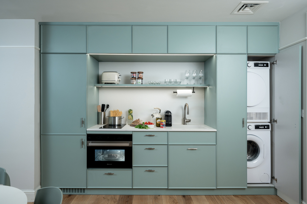 Compact yet functional kitchen in the One-Bedroom at master Mazeh Tel Aviv, designed for convenience with a contemporary layout.