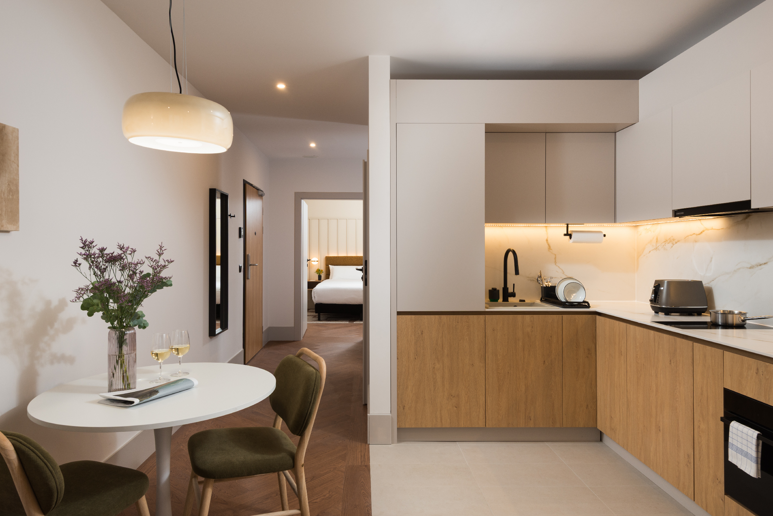 Dining area and fully equipped kitchen in a one-bedroom apartment at master Wola Serviced Apartments