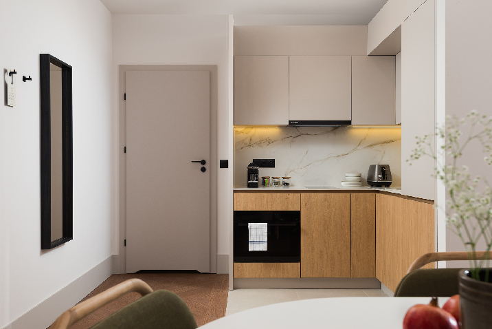 Fully equipped kitchen in master Wola two bedroom apartment with modern cabinets, built-in oven, and clean contemporary finishes