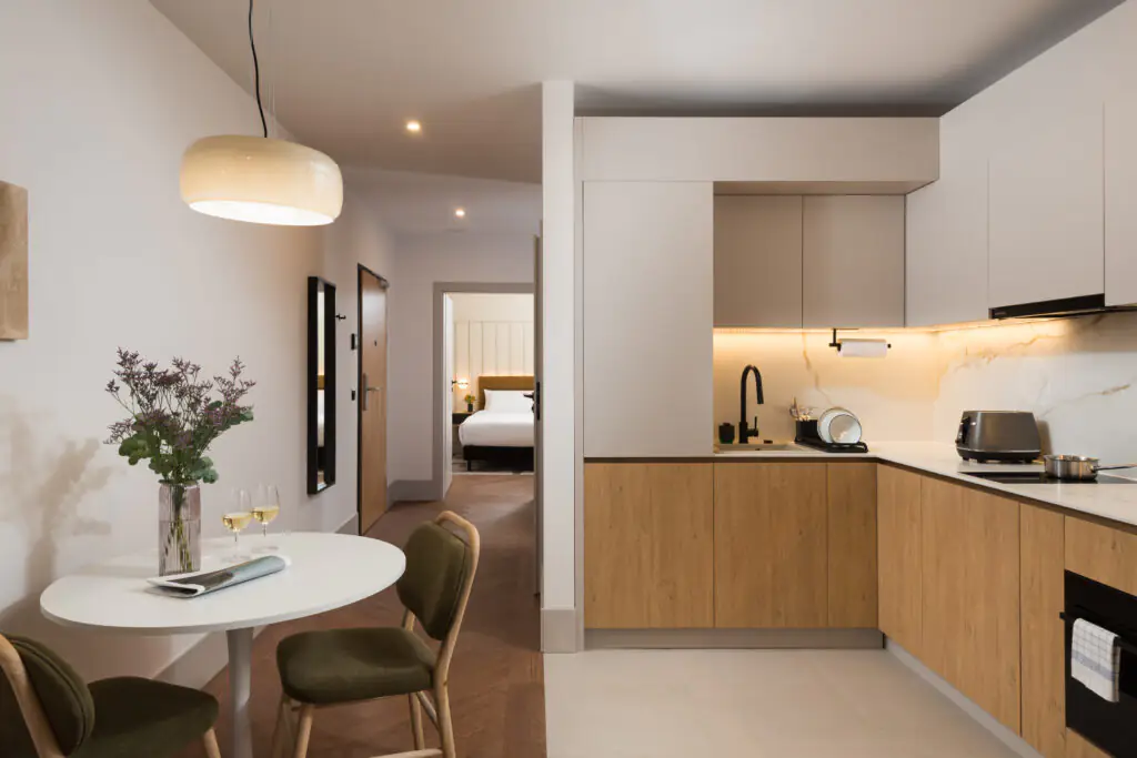 Dining area and fully equipped kitchen in a one-bedroom apartment at master Wola Serviced Apartments